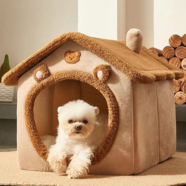 A small white dog relaxes in a soft, bear-themed KittyNook Cat Co. Universal Enclosed Pet Bed for premium comfort.